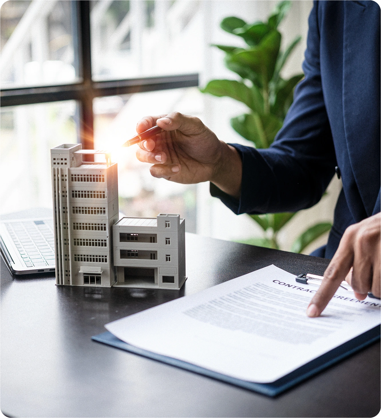 Man reviewing contract with building model.